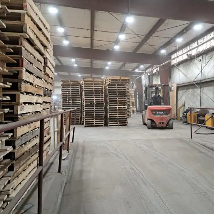 stacks of wood pallets in warehouse near forklift